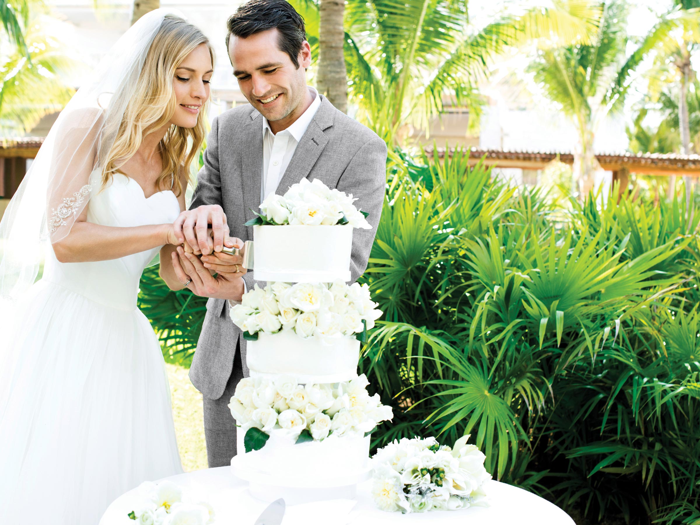 Mariés coupant leur gâteau lors de vacances-mariage à Cancun 
